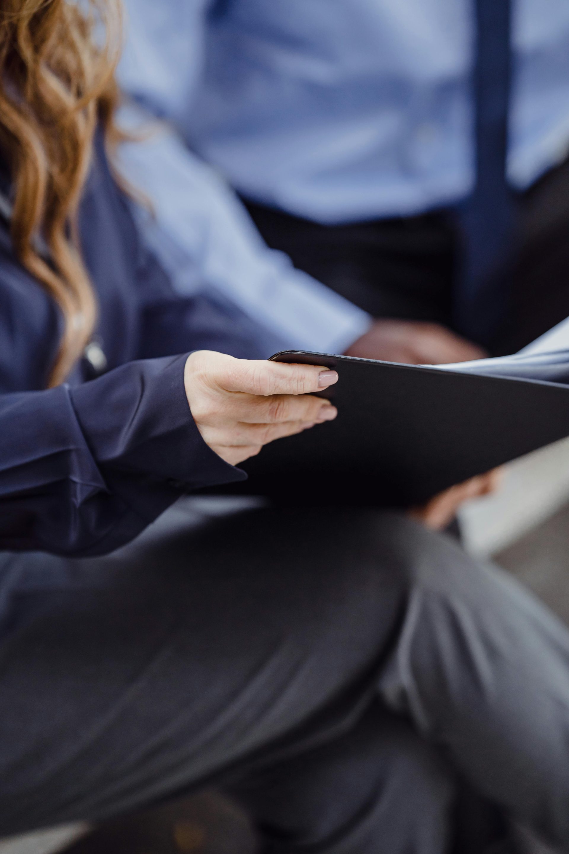 Zwei Geschäftsleute in Businesskleidung prüfen Dokumente und vermitteln damit Teamwork und Zusammenarbeit.